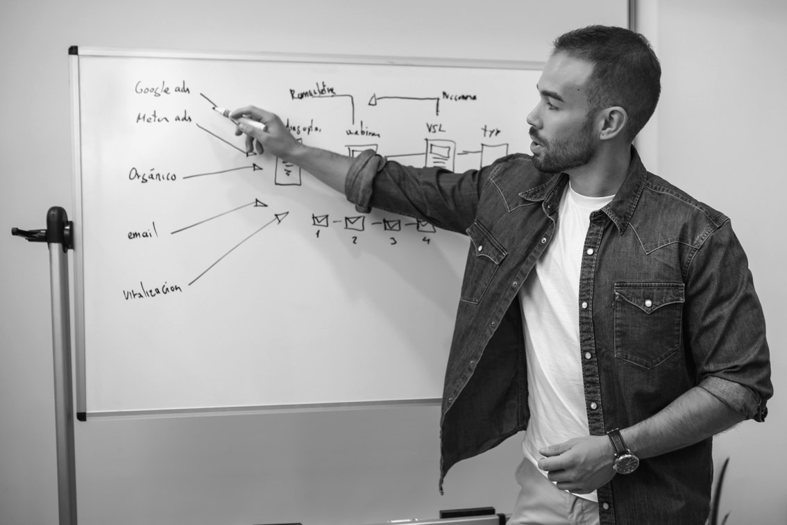 Maikel Echevarria explicando un embudo de captación en una pizarra
